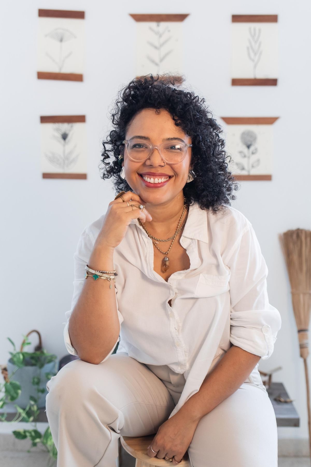 Valentina Padrón sonriendo, sentada entre plantas en Casa de Sanación